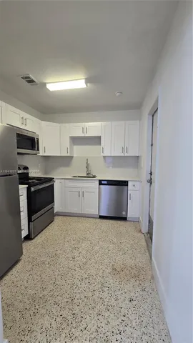 a large kitchen with cabinets and stainless steel appliances