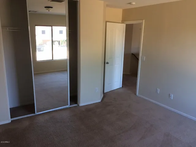 a view of a hallway with closet and wooden floor