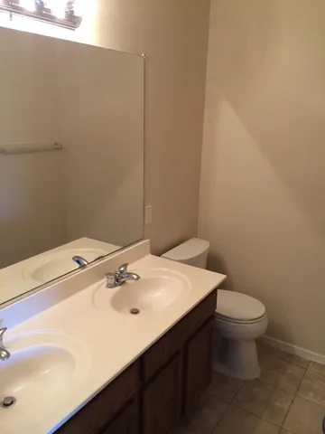 a bathroom with a sink a toilet and a mirror