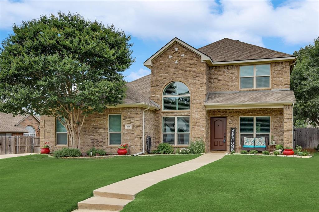 front view of a brick house with a yard