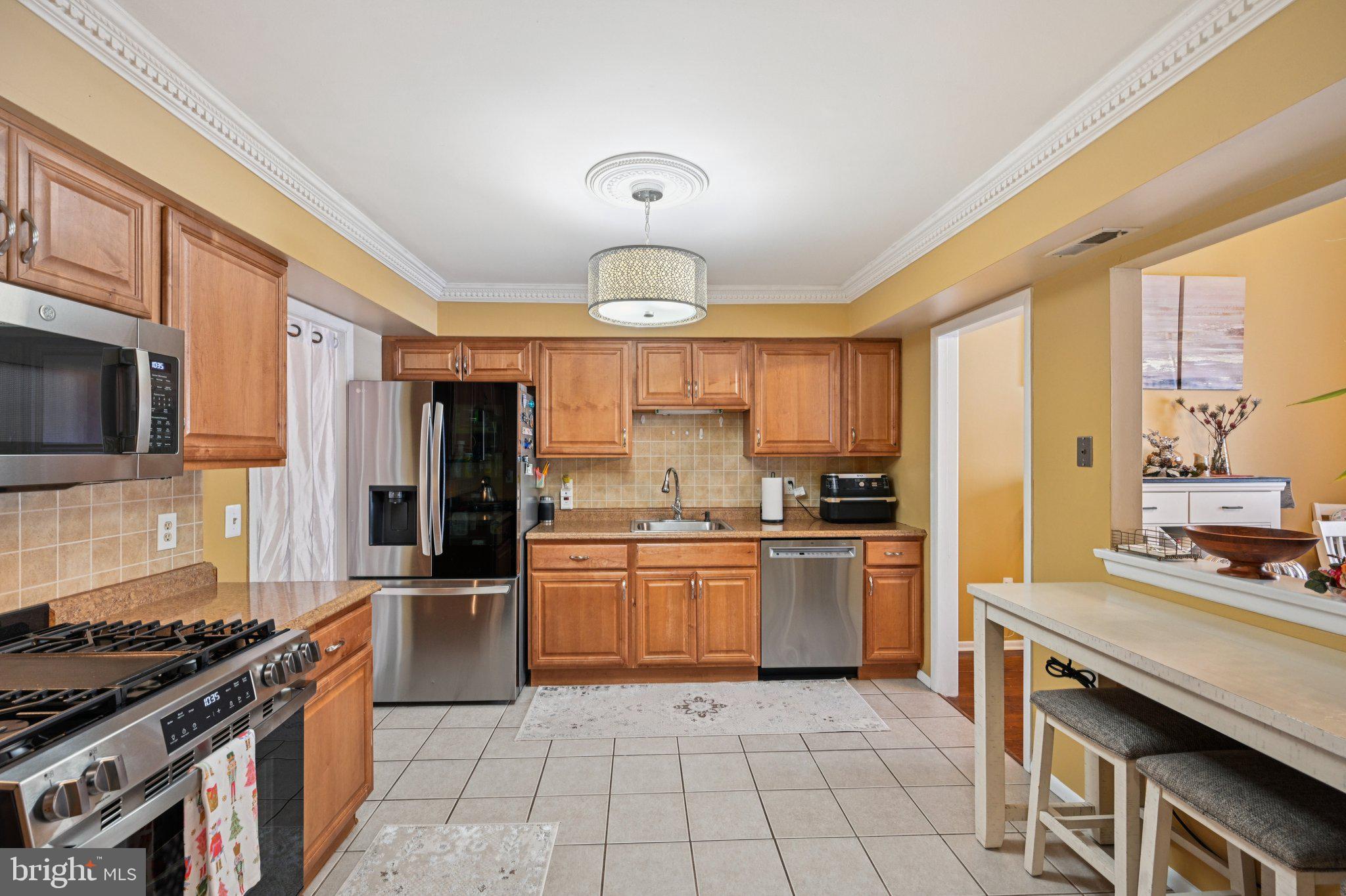 18 Jacob Court Trenton, NJ 08628 - Photo 18 of 43 a large kitchen with granite countertop a stove top oven a sink dishwasher a dining table and chairs with wooden floor