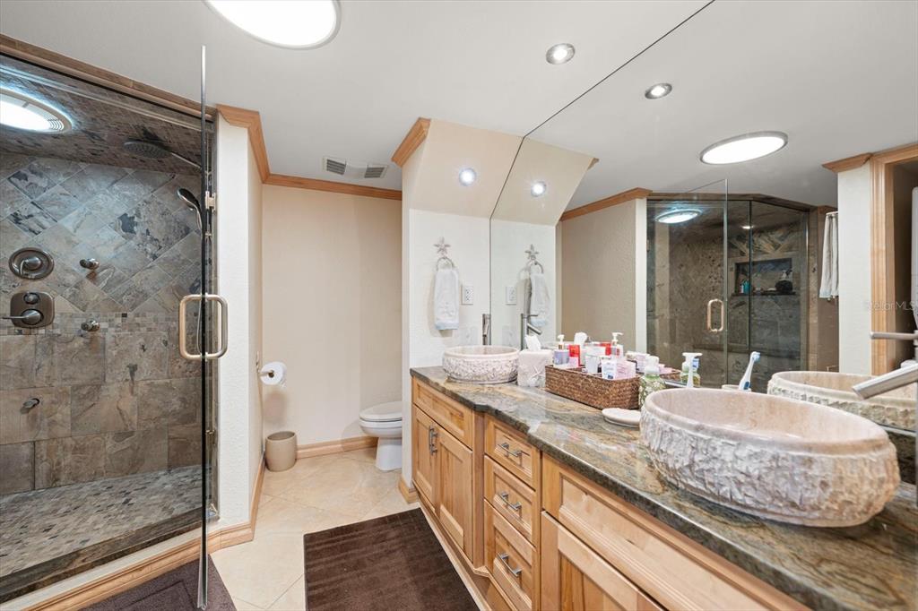 506 Gulf Boulevard, Unit 201 Indian Rocks Beach, FL 33785 - Photo 18 of 30 a bathroom with a double vanity sink mirror double and shower