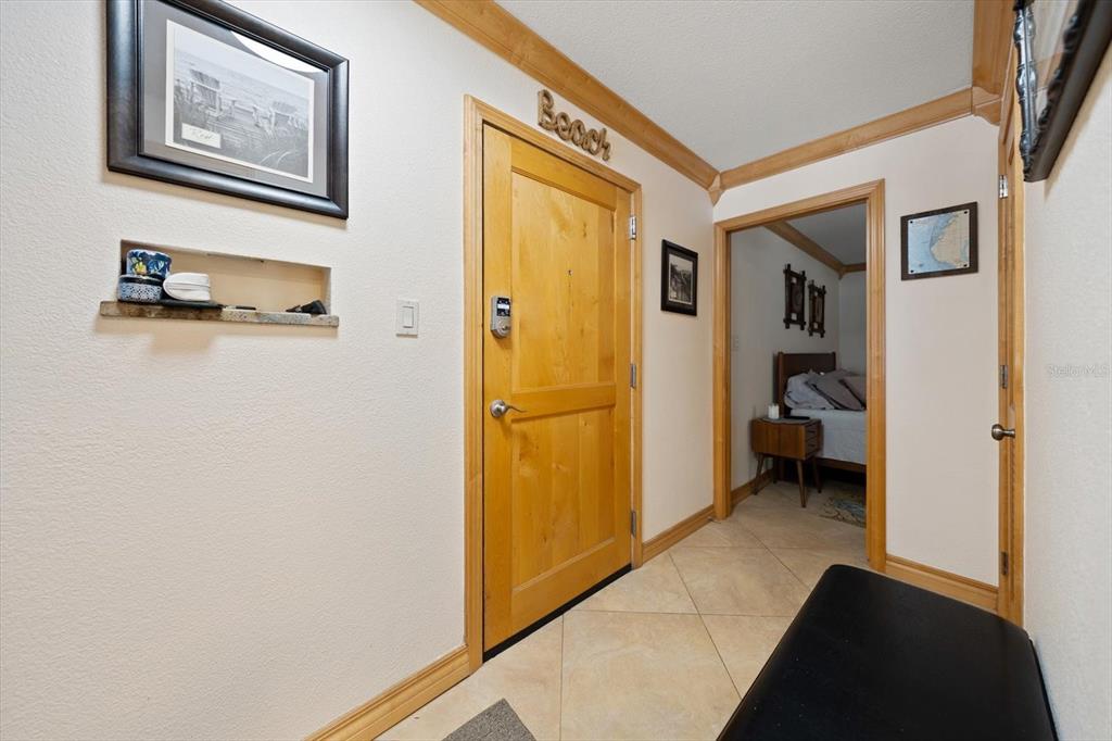 506 Gulf Boulevard, Unit 201 Indian Rocks Beach, FL 33785 - Photo 23 of 30 a view of a hallway to a livingroom with furniture and front door