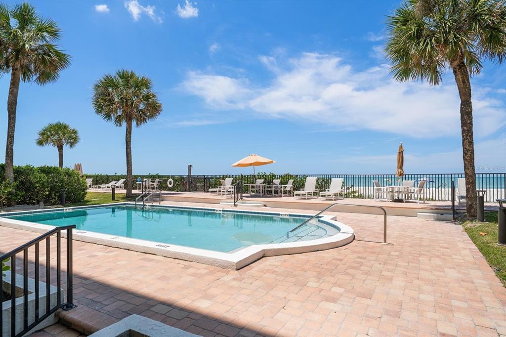506 Gulf Boulevard, Unit 201 Indian Rocks Beach, FL 33785 - Photo 27 of 30 a view of a swimming pool and a chair and table in the patio