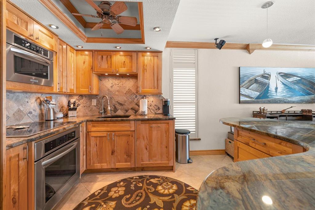 506 Gulf Boulevard, Unit 201 Indian Rocks Beach, FL 33785 - Photo 5 of 30 a kitchen with stainless steel appliances granite countertop a stove a sink and a microwave