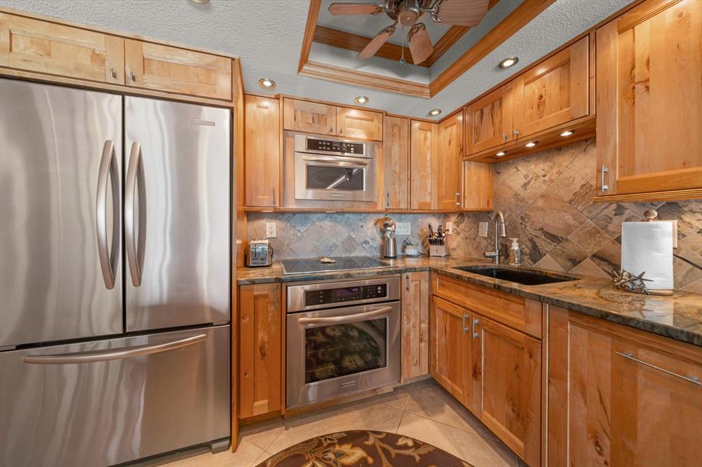 506 Gulf Boulevard, Unit 201 Indian Rocks Beach, FL 33785 - Photo 6 of 30 a kitchen with stainless steel appliances a refrigerator sink and cabinets
