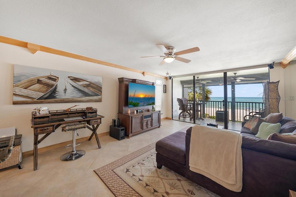 506 Gulf Boulevard, Unit 201 Indian Rocks Beach, FL 33785 - Photo 10 of 30 a living room with furniture a ceiling fan and a flat screen tv