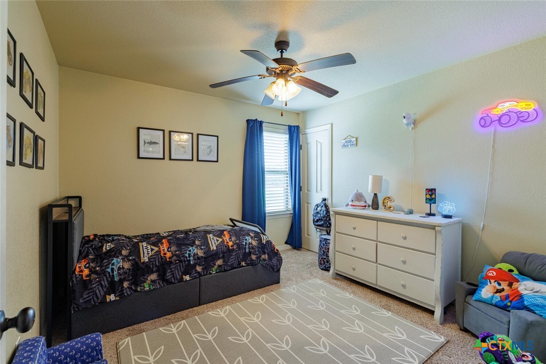 910 Ridgeoak Drive Belton, TX 76513 - Photo 27 of 48 a bedroom with a bed and a chandelier