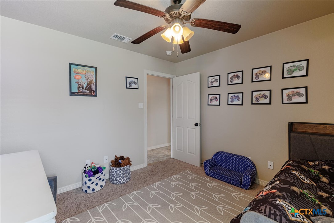 910 Ridgeoak Drive Belton, TX 76513 - Photo 28 of 48 a bedroom with a bed and a chandelier