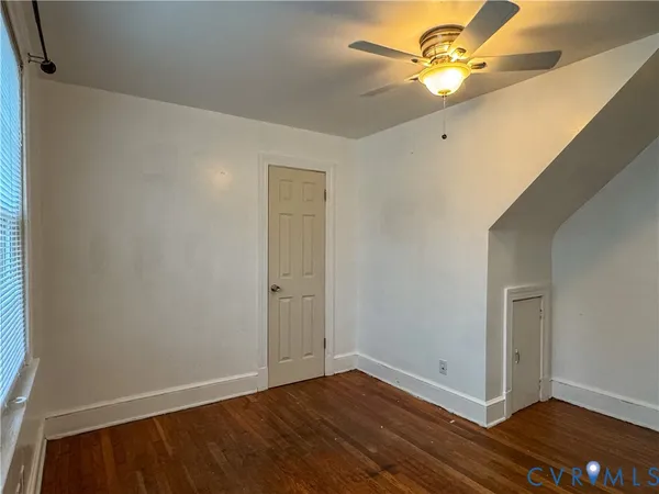 a view of room with hardwood floor and a ceiling fan