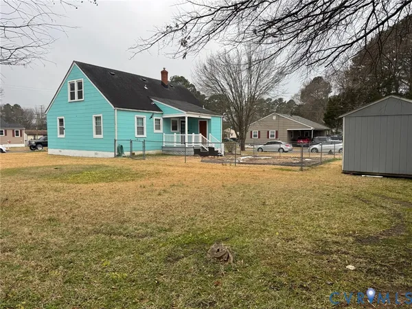 a front view of house with yard and trees in the background