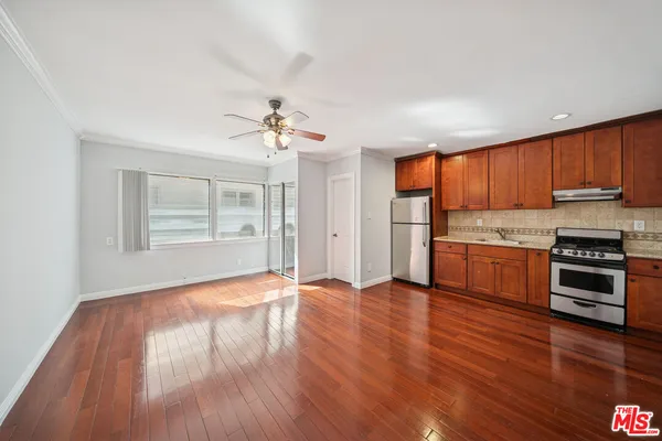 a view of kitchen with granite countertop wooden floors and stainless steel appliances