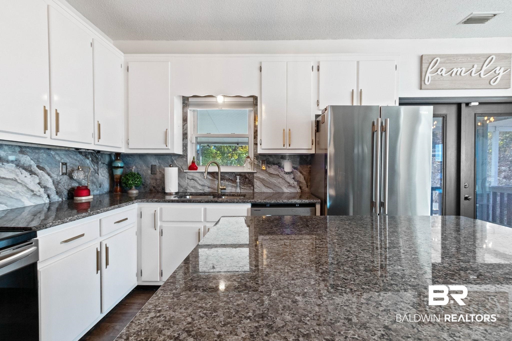 41997 Bayou Road Bay Minette, AL 36507 - Photo 6 of 68 Kitchen featuring dark stone countertops, white cabinetry, and backsplash