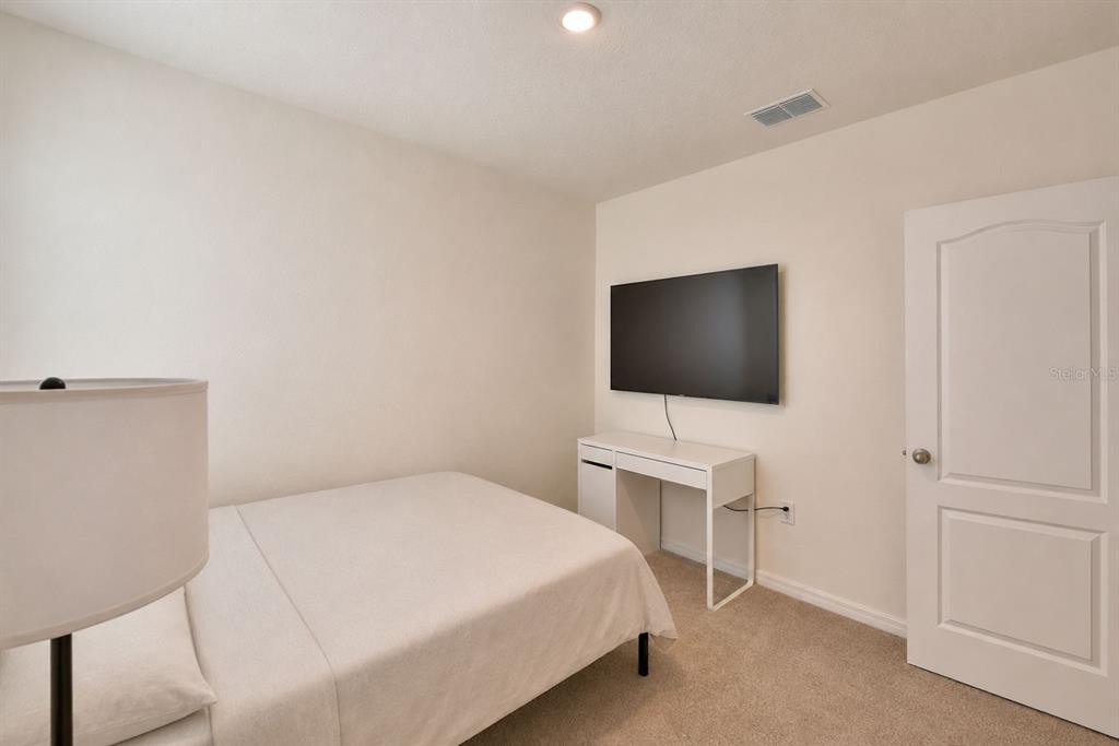 2839 Moulin Road Davenport, FL 33837 - Photo 42 of 75 a bedroom with a bed and a flat screen tv