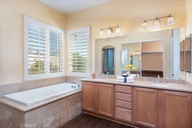 a bathroom with a tub sink and mirror