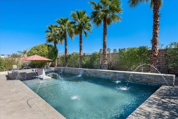 a view of a swimming pool with a table and chairs under an umbrella