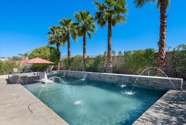 a view of a swimming pool with a table and chairs under an umbrella