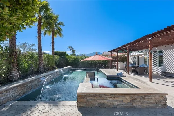 a view of a house with pool and sitting area