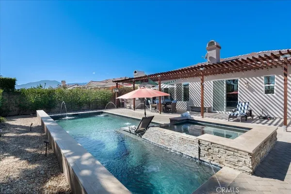 a view of a house with pool and chairs