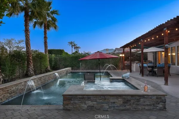 a view of a house with swimming pool and sitting area