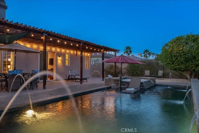 a view of swimming pool with a table and chairs under an umbrella