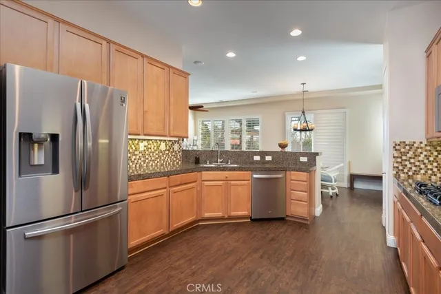 a kitchen with granite countertop stainless steel appliances a refrigerator a sink and a stove
