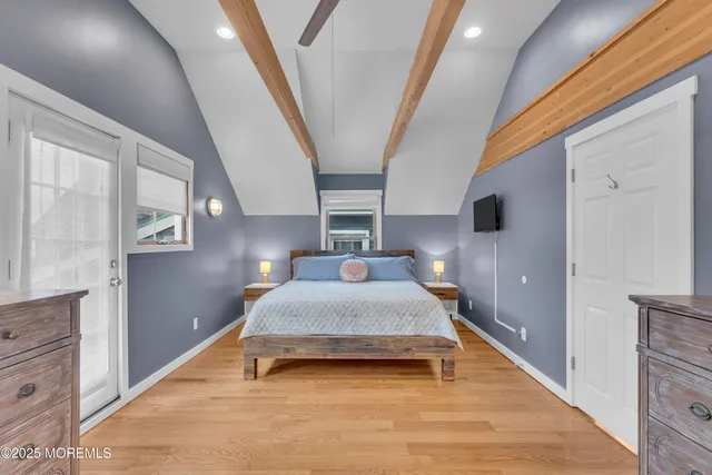 a spacious bedroom with a bed and wooden floor