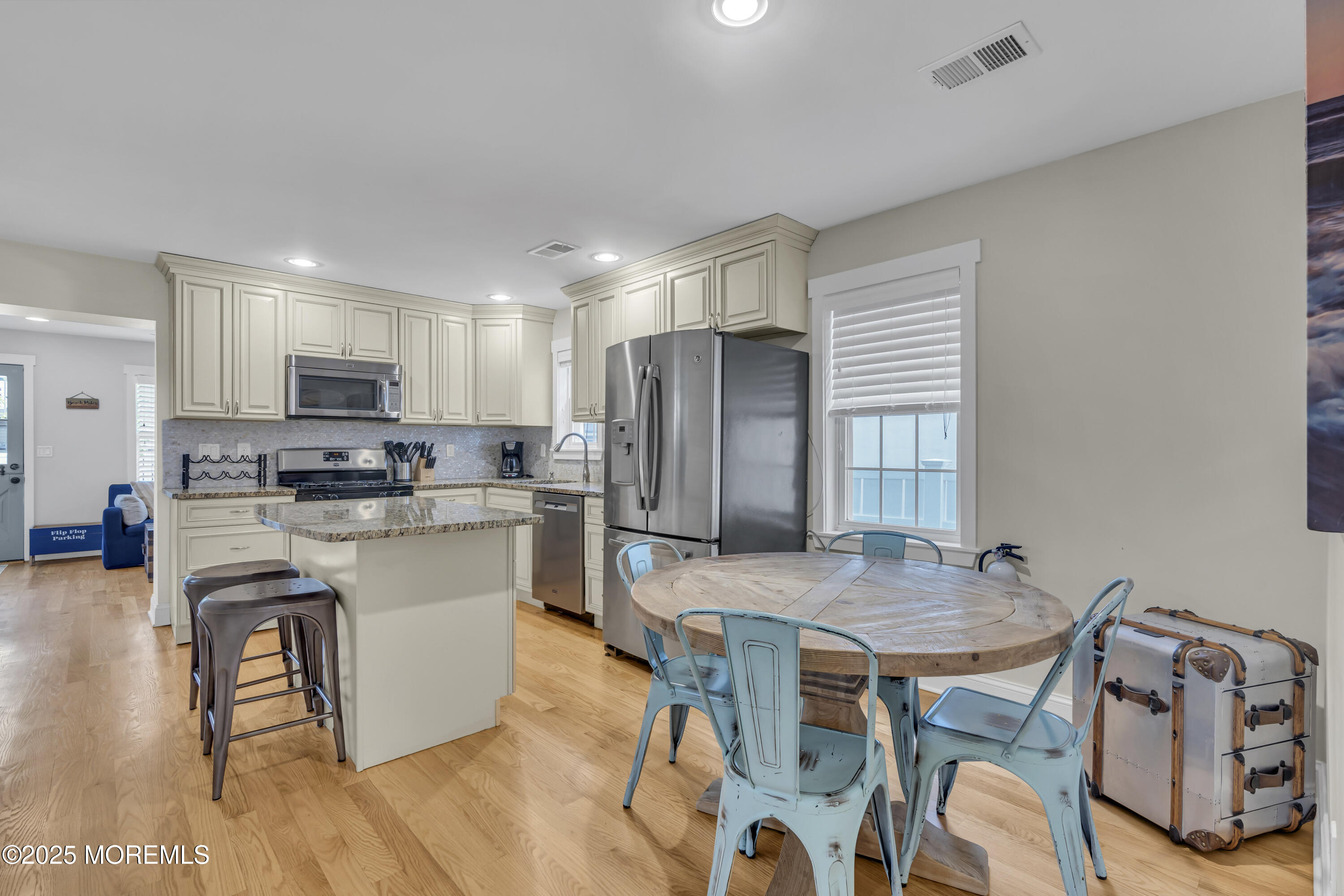 196 3rd Avenue Manasquan, NJ 08736 - Photo 8 of 36 a kitchen with granite countertop a table chairs microwave and cabinets
