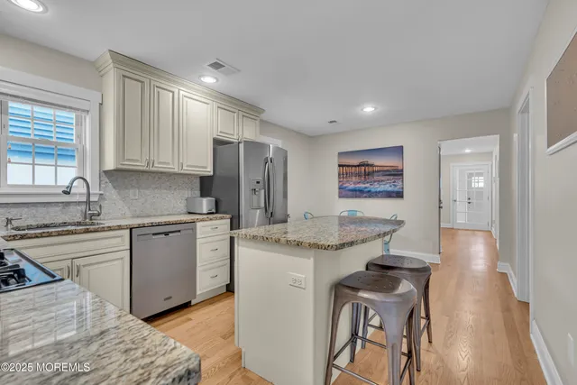 a kitchen with granite countertop cabinets stainless steel appliances and a counter space