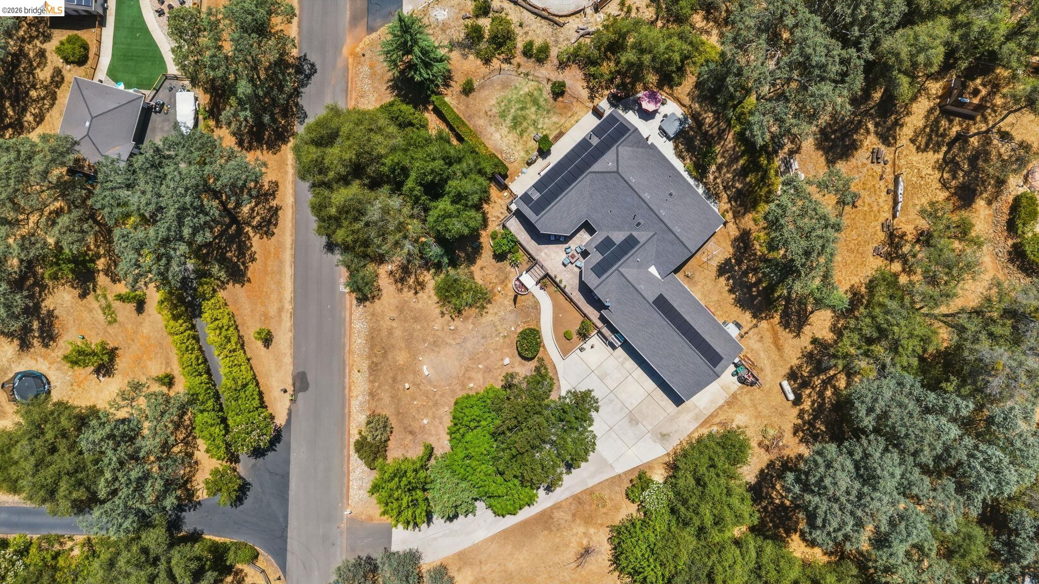 18570 Pradera Real Road Sonora, CA 95370 - Photo 65 of 66 Expansive property featuring a grey shingle roof, solar panel installations, and a concrete driveway