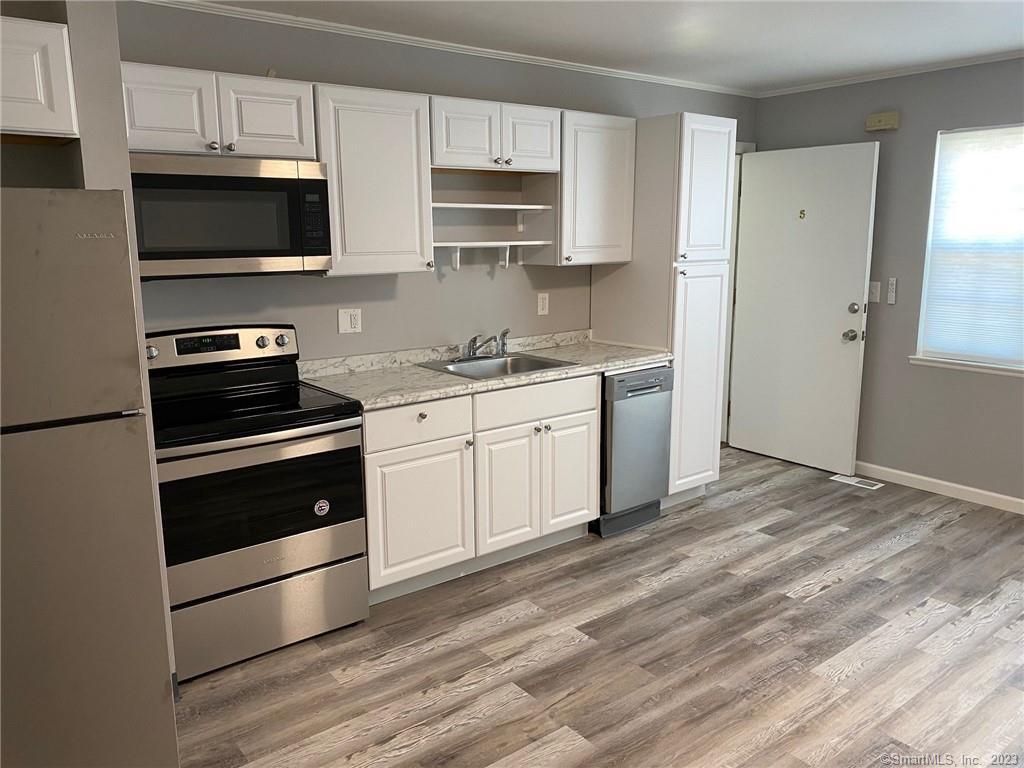 5 Village Walk, Unit 5 Wilton, CT 06897 - Photo 3 of 15 a kitchen with stainless steel appliances a stove microwave and sink