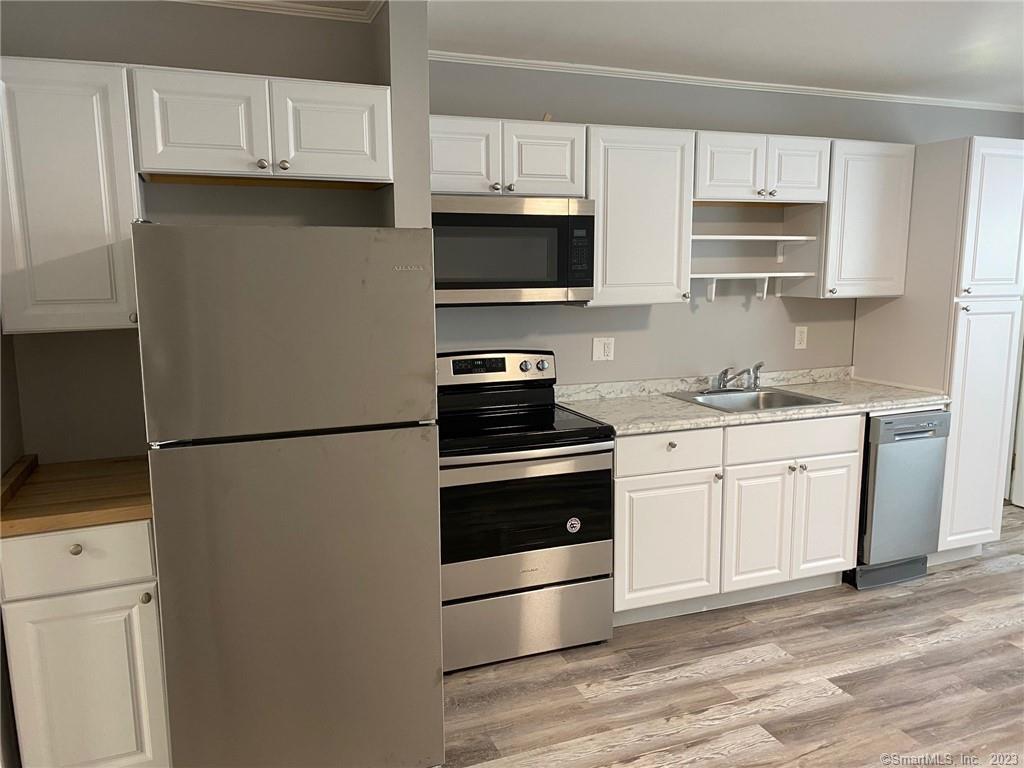 5 Village Walk, Unit 5 Wilton, CT 06897 - Photo 4 of 15 a kitchen with white cabinets and stainless steel appliances