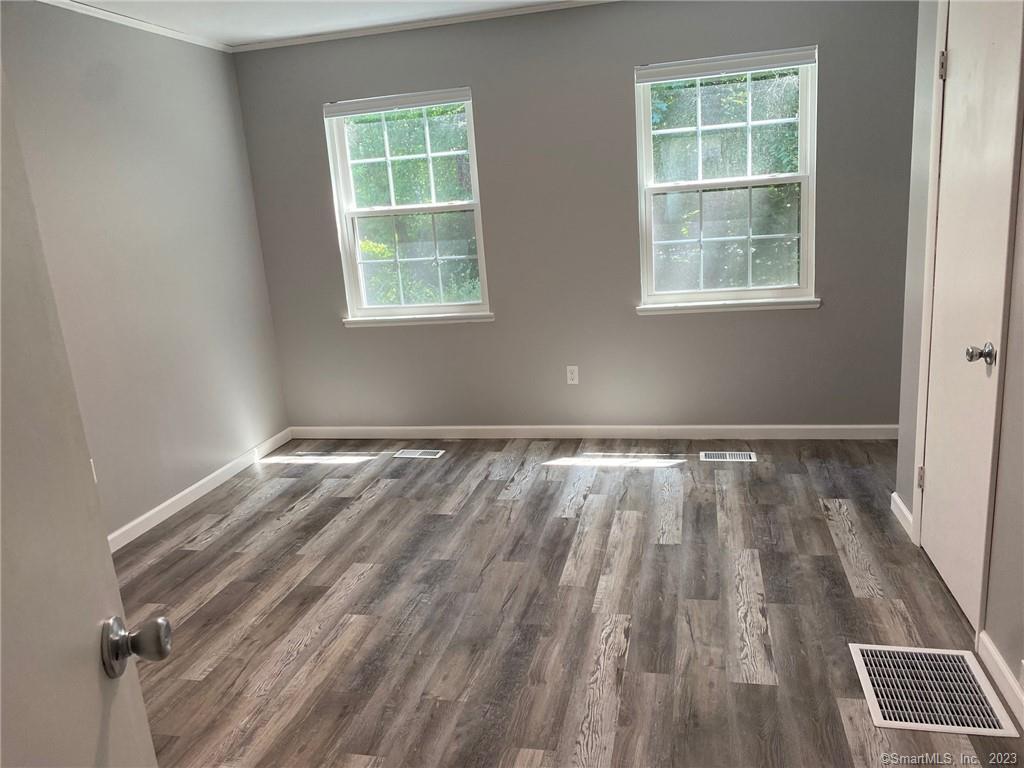 5 Village Walk, Unit 5 Wilton, CT 06897 - Photo 10 of 15 an empty room with wooden floor and windows