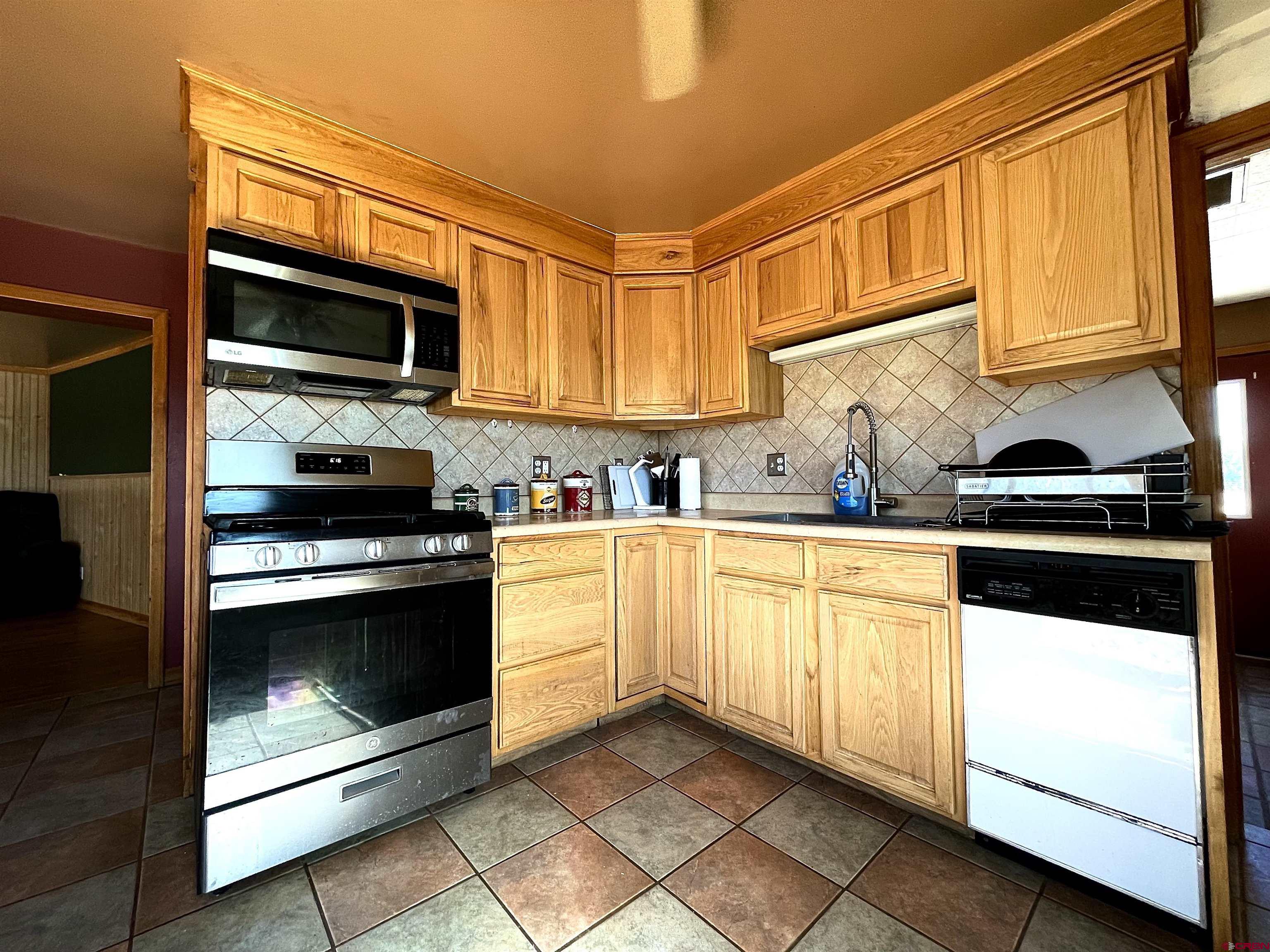 54867 Banner Road Delta, CO 81416 - Photo 17 of 33 a kitchen with stainless steel appliances granite countertop a stove microwave and sink