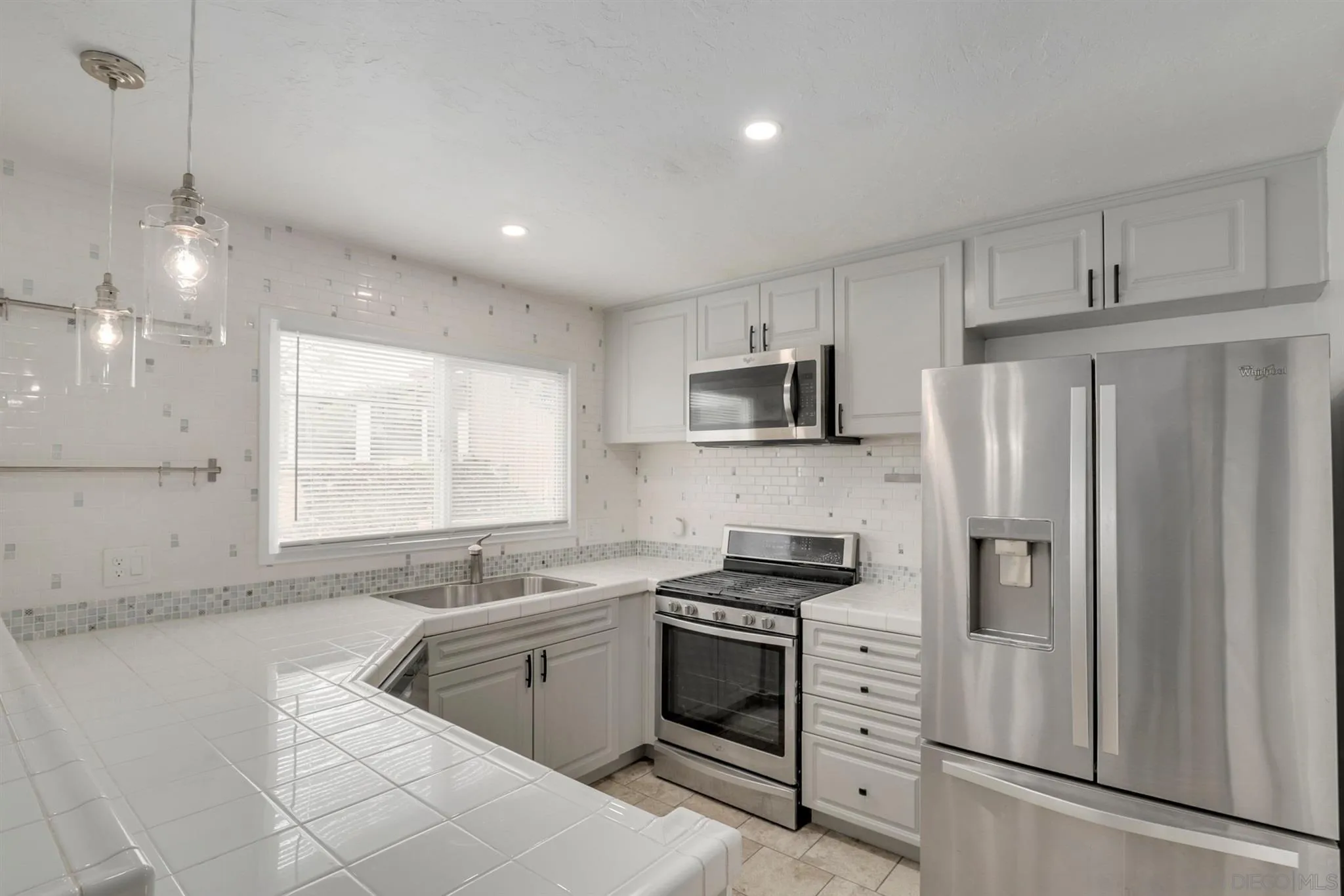 9753 Settle Road Santee, CA 92071 - Photo 4 of 31 a kitchen with white cabinets and stainless steel appliances