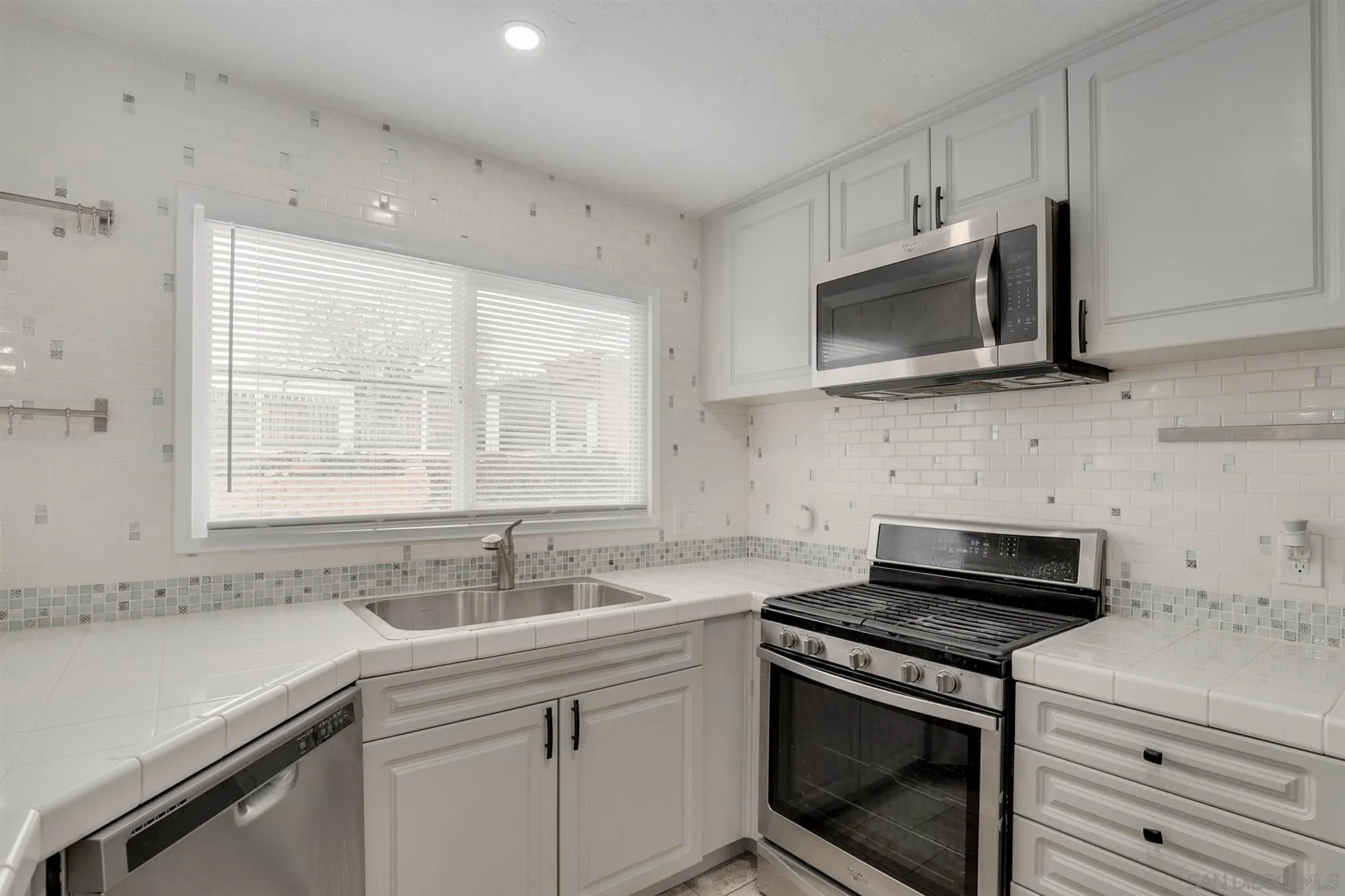 9753 Settle Road Santee, CA 92071 - Photo 5 of 31 a kitchen with stainless steel appliances granite countertop white cabinets a sink and a stove