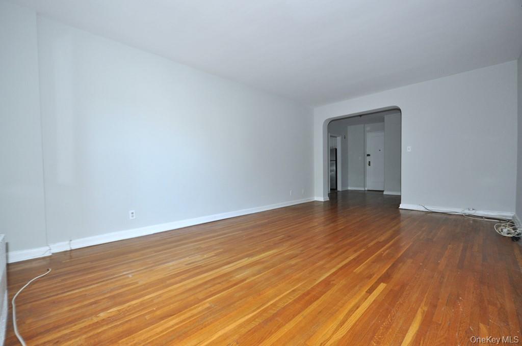 Large Corner Living Room with Hardwood floors opens to the dining foyer and overlooking Tree Lined Garth Road.  The living room is 19'-10" x 12'-2".