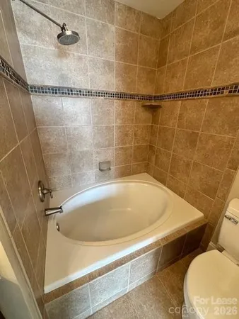 a bath tub sitting next to a white toilet