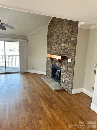 an empty room with wooden floor and fireplace