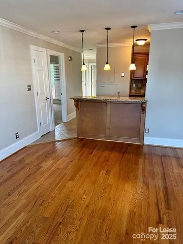a view of a kitchen with wooden floor and cabinets
