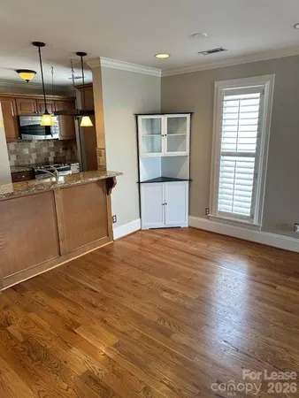 a view of a kitchen with wooden floor and electronic appliances