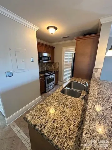 a kitchen with granite countertop a stove and a sink