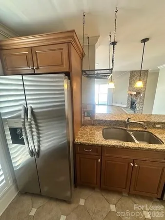 a kitchen with granite countertop a sink and a refrigerator