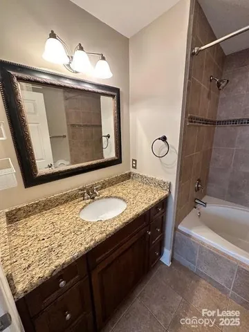 a bathroom with a granite countertop sink a mirror and shower