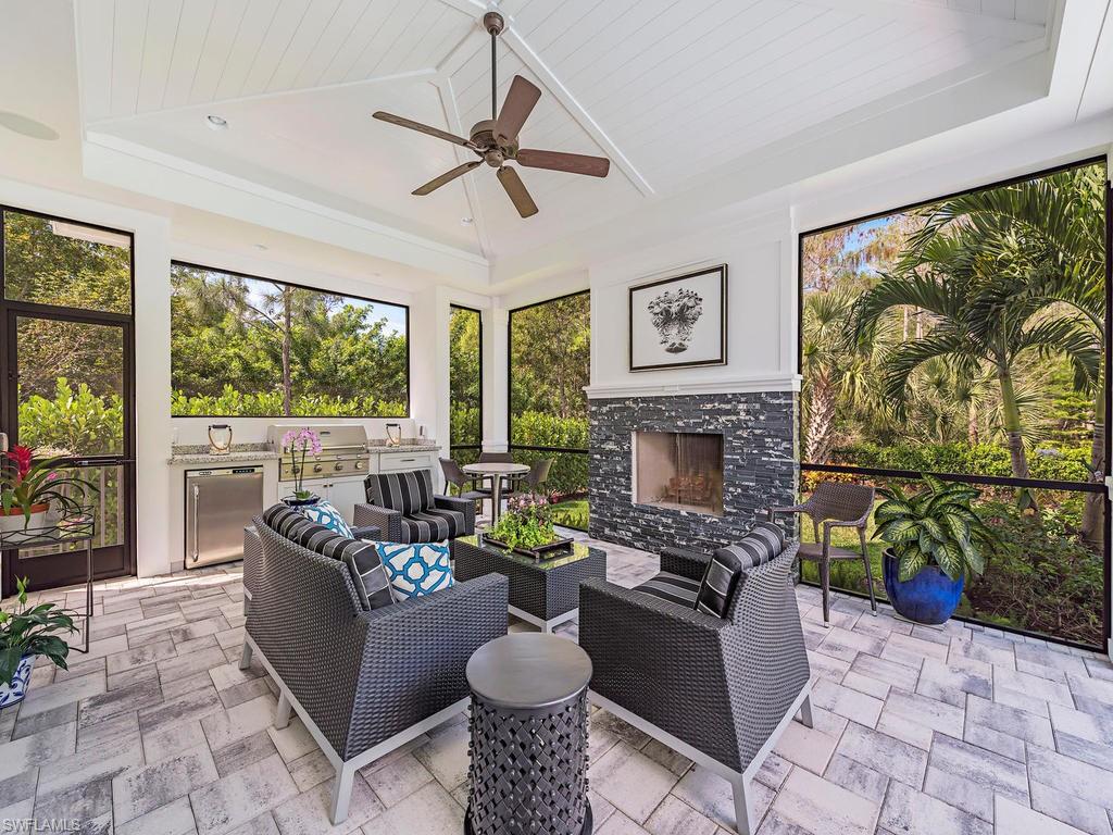 2305 Harrier Run Naples, FL 34105 - Photo 13 of 15 a living room with furniture a flat screen tv and a fireplace