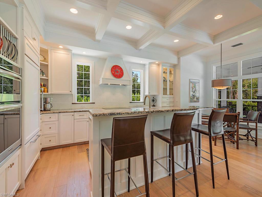 2305 Harrier Run Naples, FL 34105 - Photo 7 of 15 a kitchen with a table chairs and white cabinets