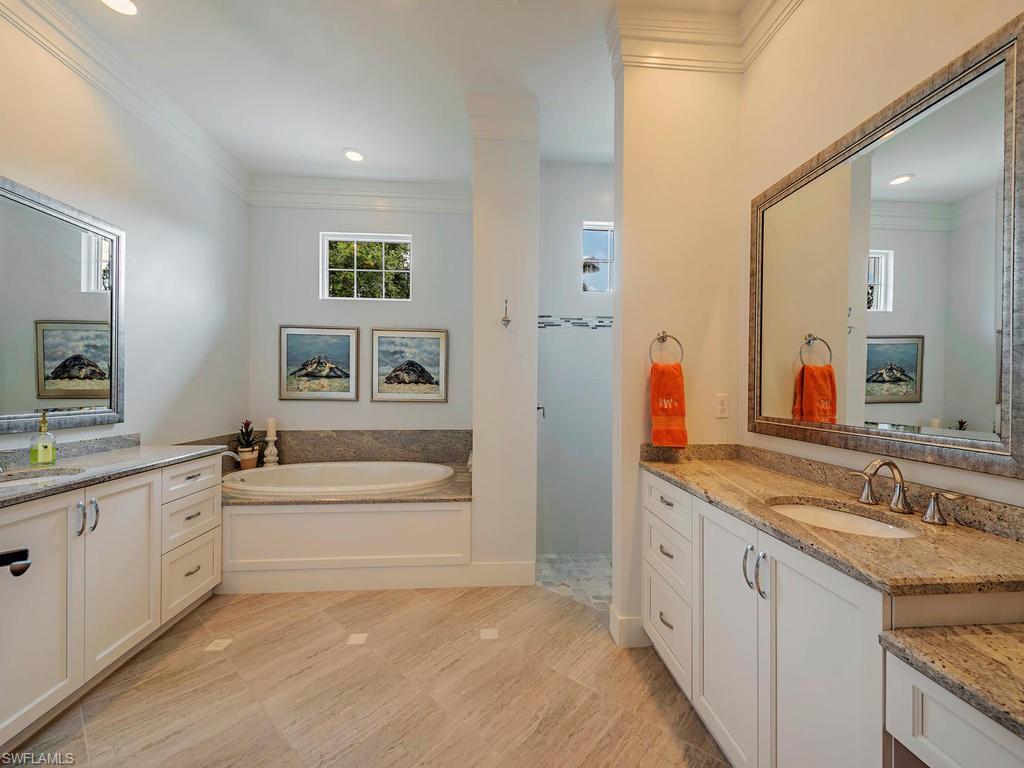 2305 Harrier Run Naples, FL 34105 - Photo 9 of 15 a spacious bathroom with a granite countertop sink a large mirror and a bathtub