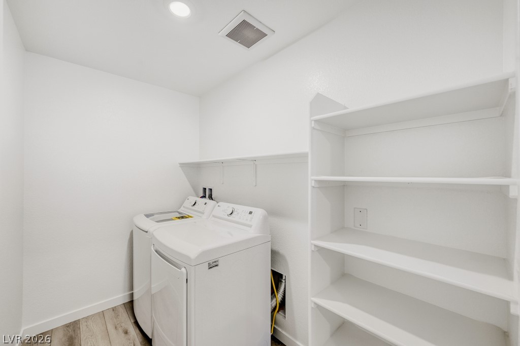 773 Fallen Phoenix Street Henderson, NV 89011 - Photo 23 of 28 Laundry area featuring washing machine and dryer and light wood-style flooring