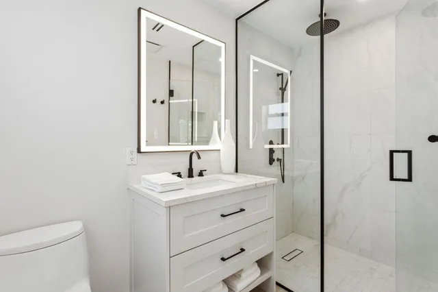 a kitchen with stainless steel appliances kitchen island granite countertop a table chairs stove and white cabinets