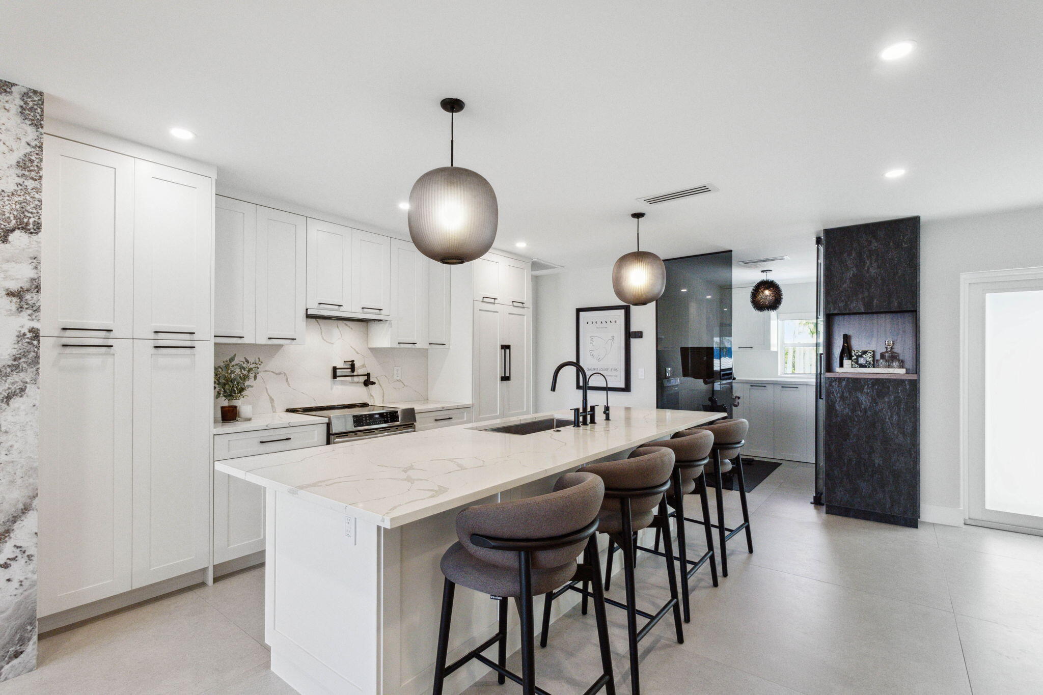 3401 South Ocean Boulevard, Unit 6 Highland Beach, FL 33487 - Photo 16 of 33 a kitchen with stainless steel appliances kitchen island granite countertop a table chairs stove and white cabinets